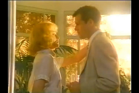 Man and woman in foreground, closely facing each other, with bright sun in background.