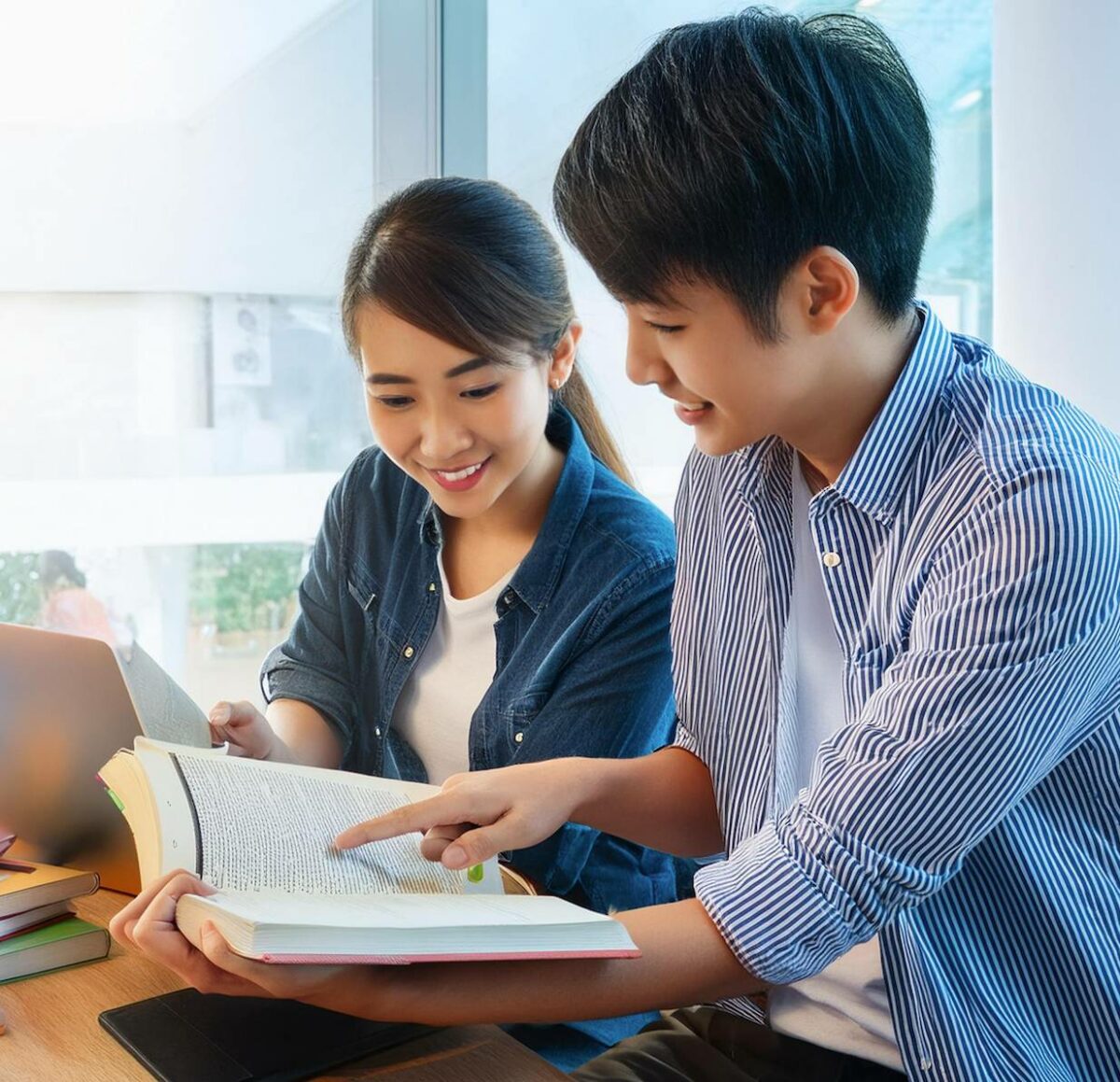 Picture of two college students reading a book